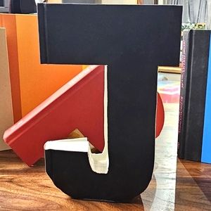 Selling the letter J. Handcut from a black book.